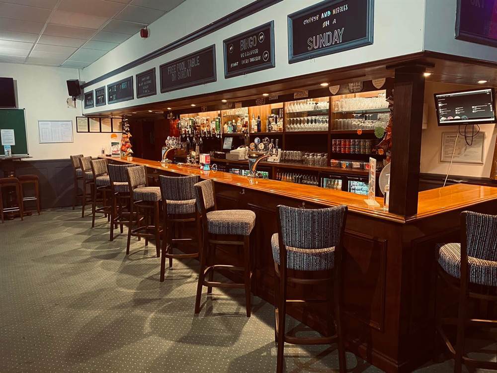 The main bar at the Club, with stools along the counter